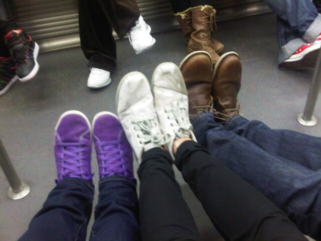 Three pairs of shoes on the subway home after a fun day.